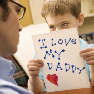 Boy giving dad drawing.